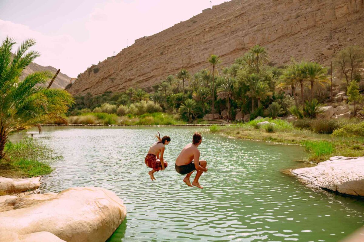 Touristes qui sautent dans l'eau d'un oasis