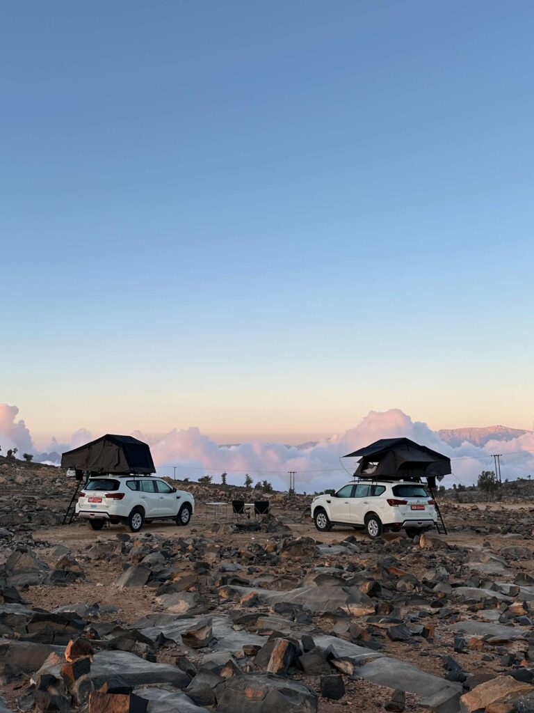 4x4 avec des tentes de toit dans les montagnes au dessus des nuages