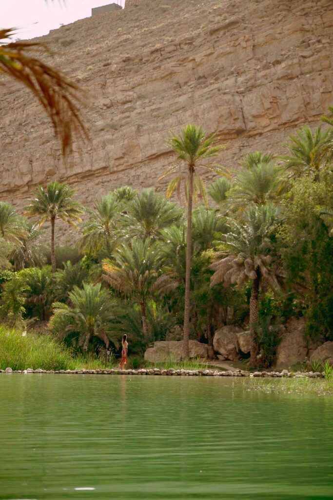 Une femme qui marche le long de l'eau à Oman